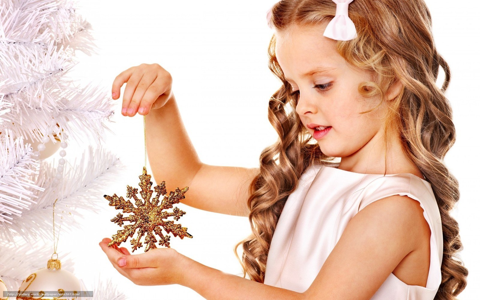 girl decorating white christmas tree