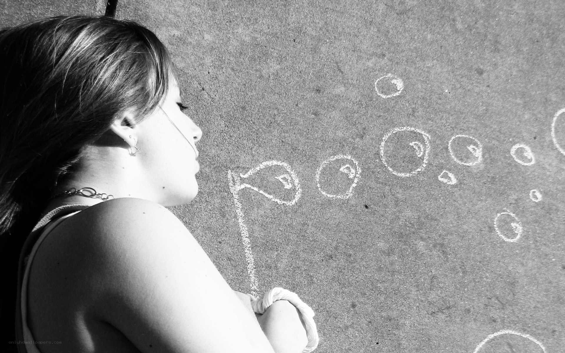 Girl drawing bubbles on pavement