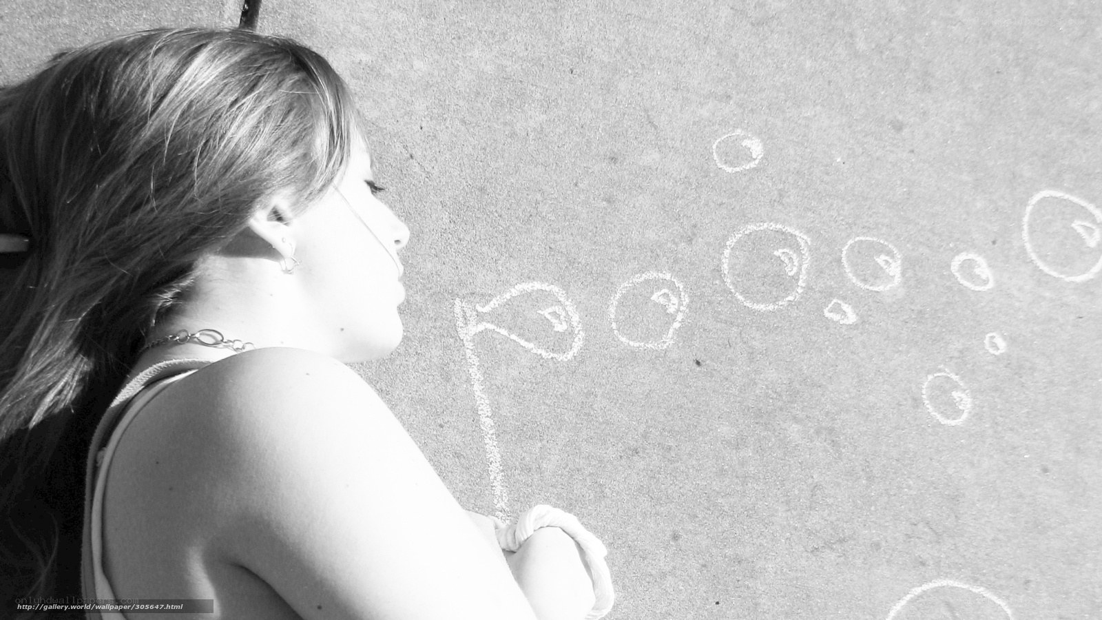 Girl drawing bubbles on pavement