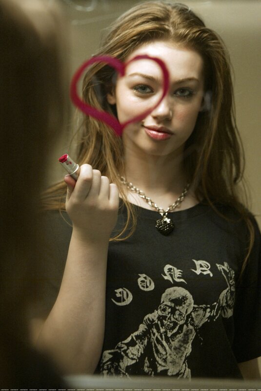 girl drawing heart on mirror