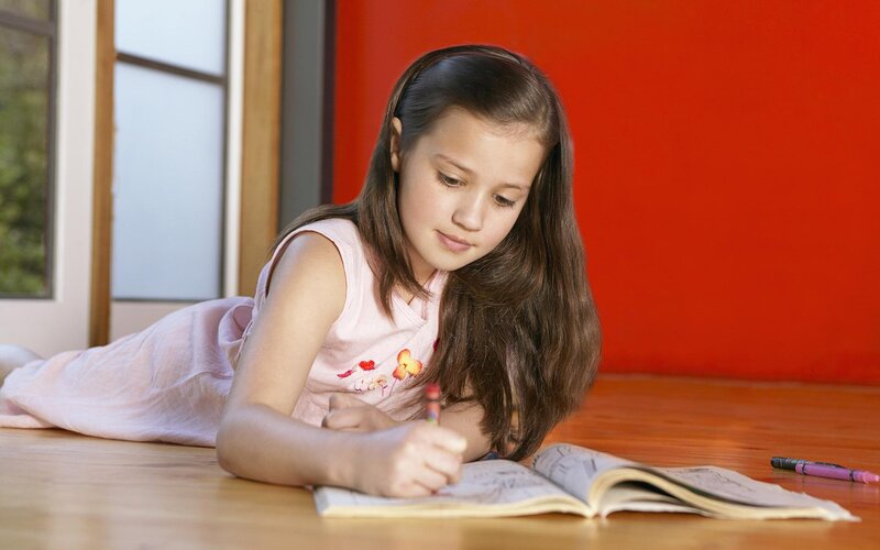 Girl Drawing in Notebook