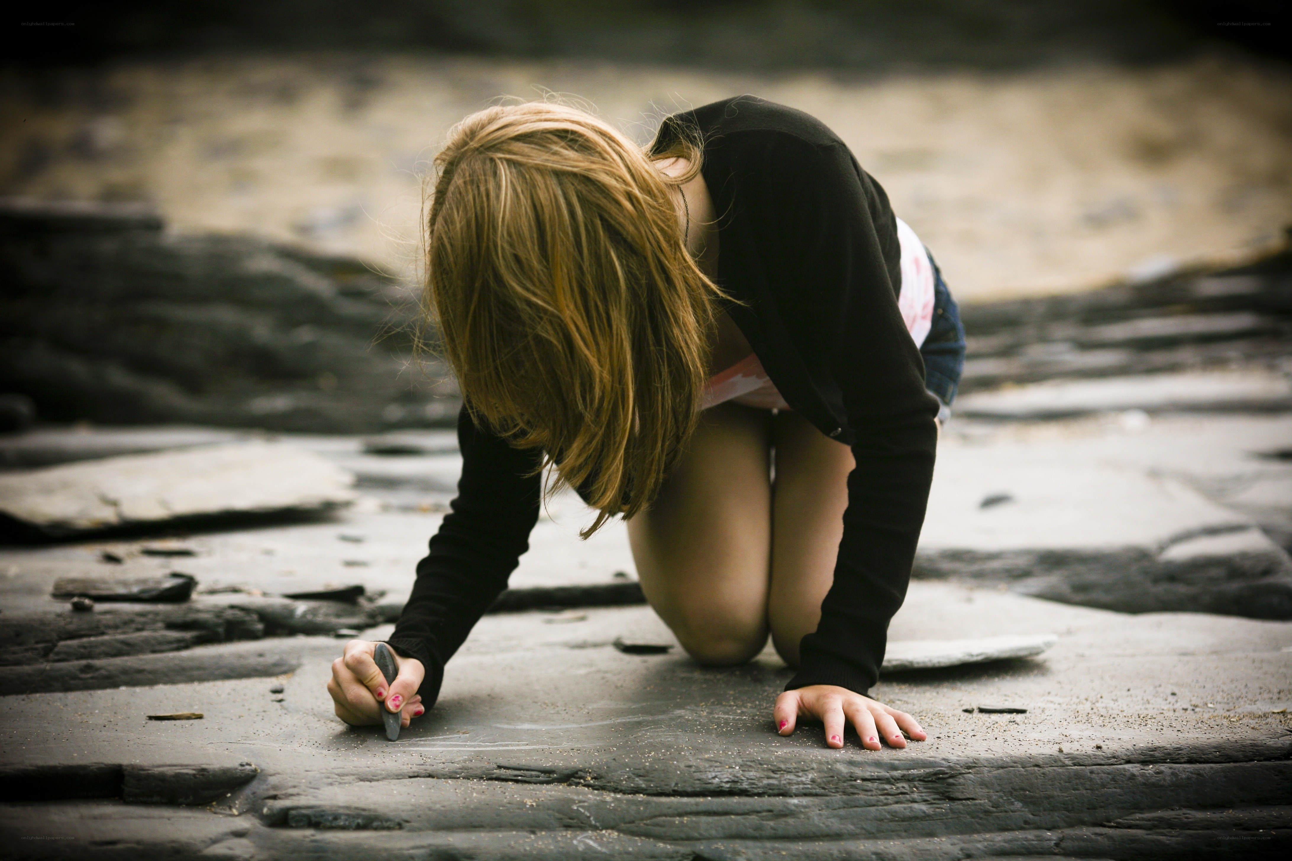 Girl drawing on stone