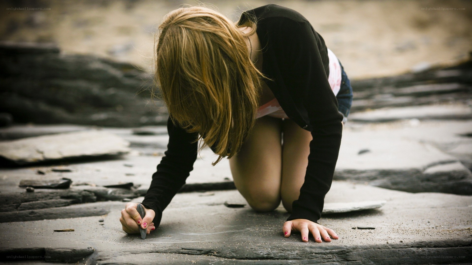 girl drawing on stone