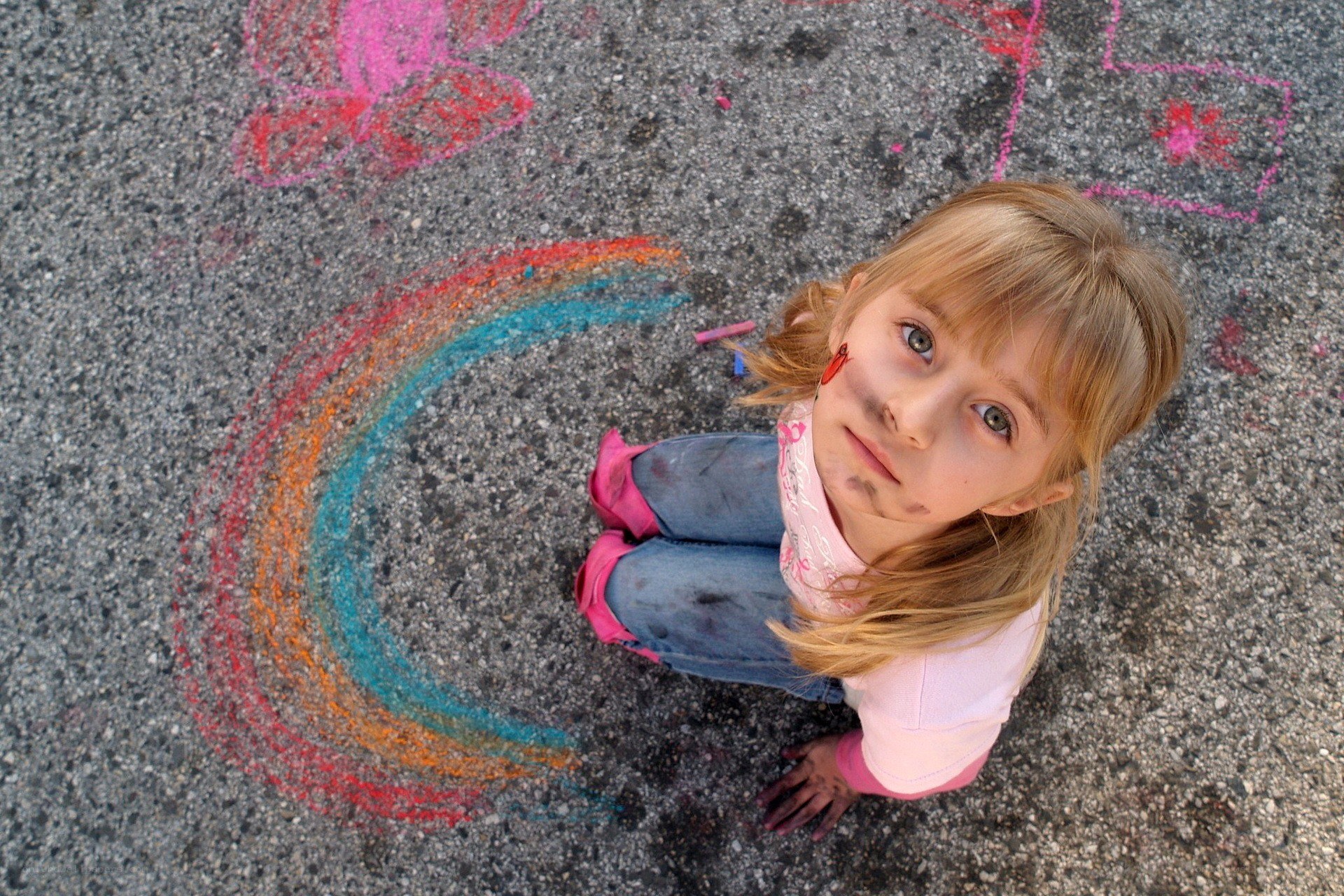 girl drawing rainbow with chalk