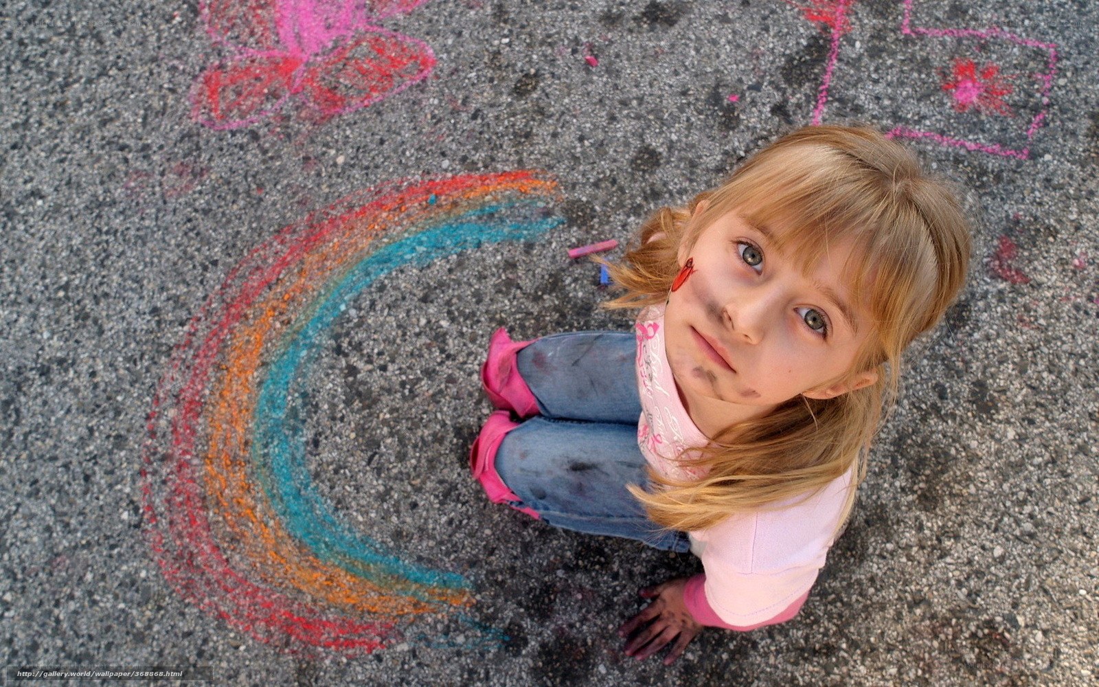 Girl drawing rainbow with chalk