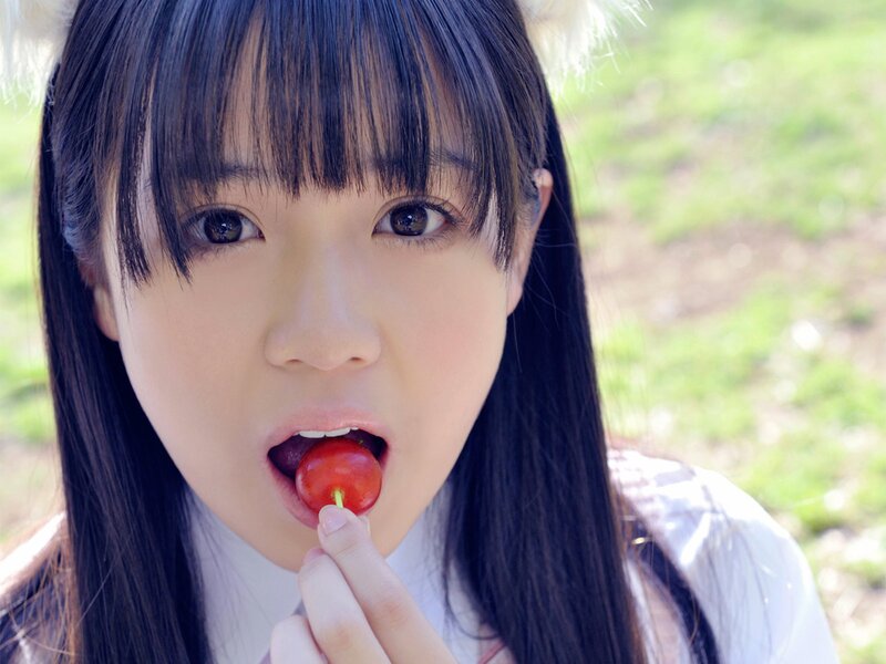 girl eating cherry outdoors