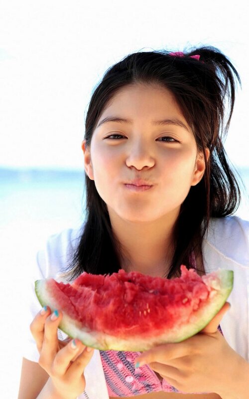 girl eating watermelon at beach