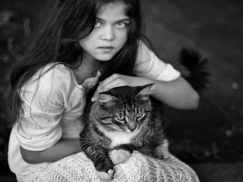 Girl Holding a Cat — Black, Serious