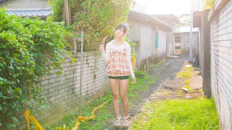 Girl holding a sausage in an alley