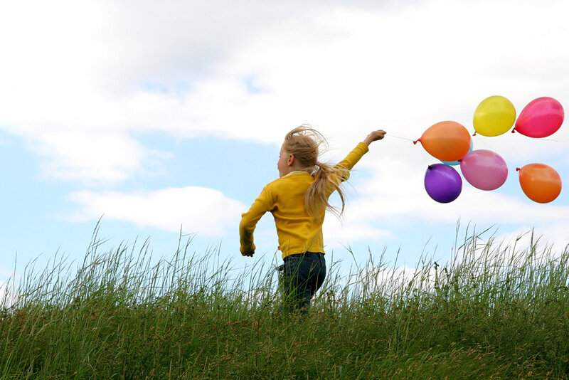 Girl Holding Balloons — Yellow