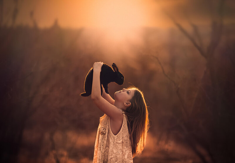 Girl Holding Black Rabbit — Orange