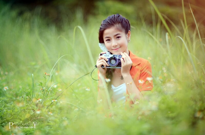 Girl Holding Camera — Green, Serene, Afternoon