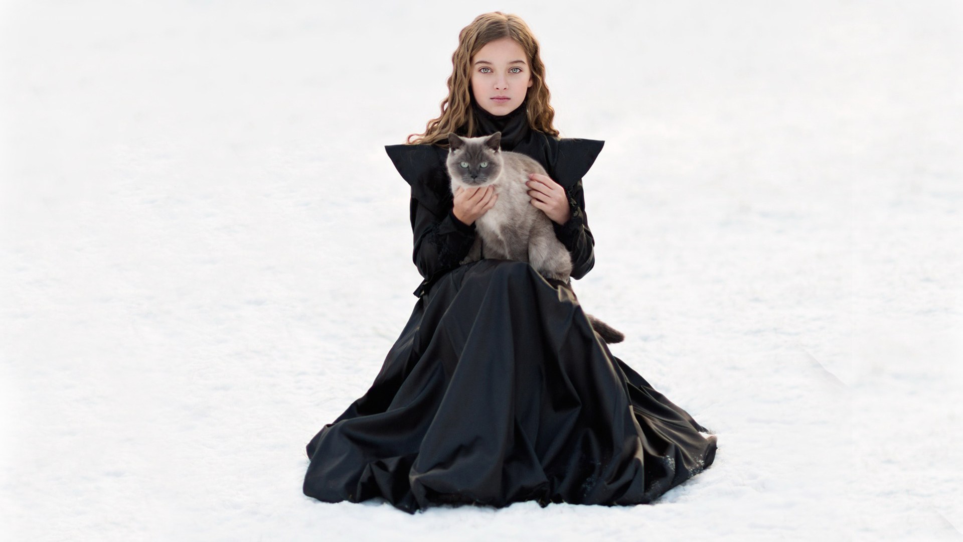 girl holding cat in snow