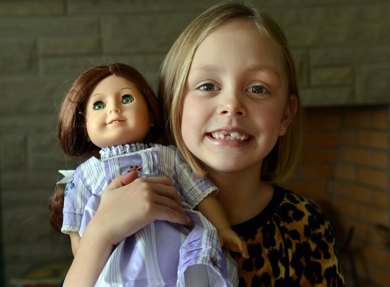 Girl Holding Doll — Brown, Happy