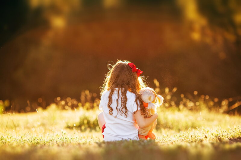 Girl Holding Doll — Golden