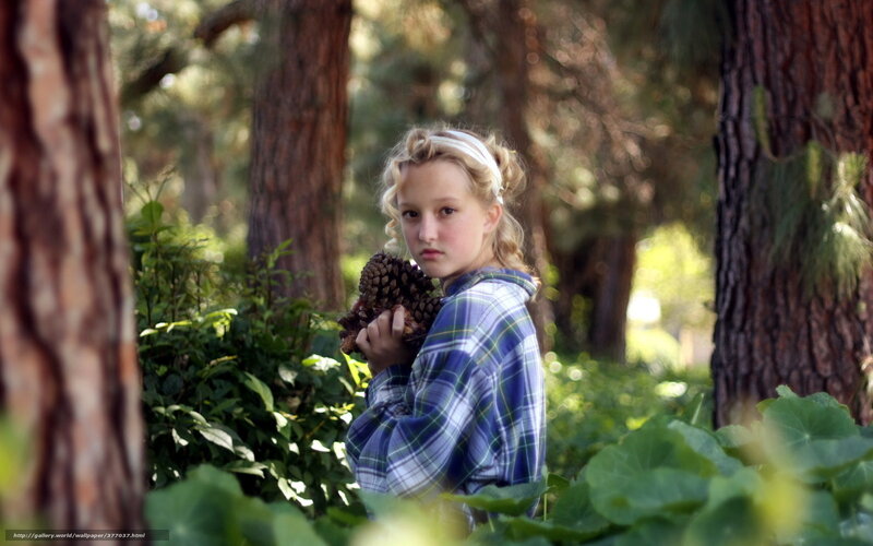 Girl holding pinecones in forest