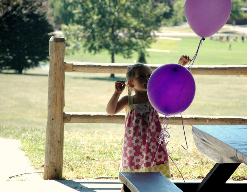 Girl Holding Purple Balloons