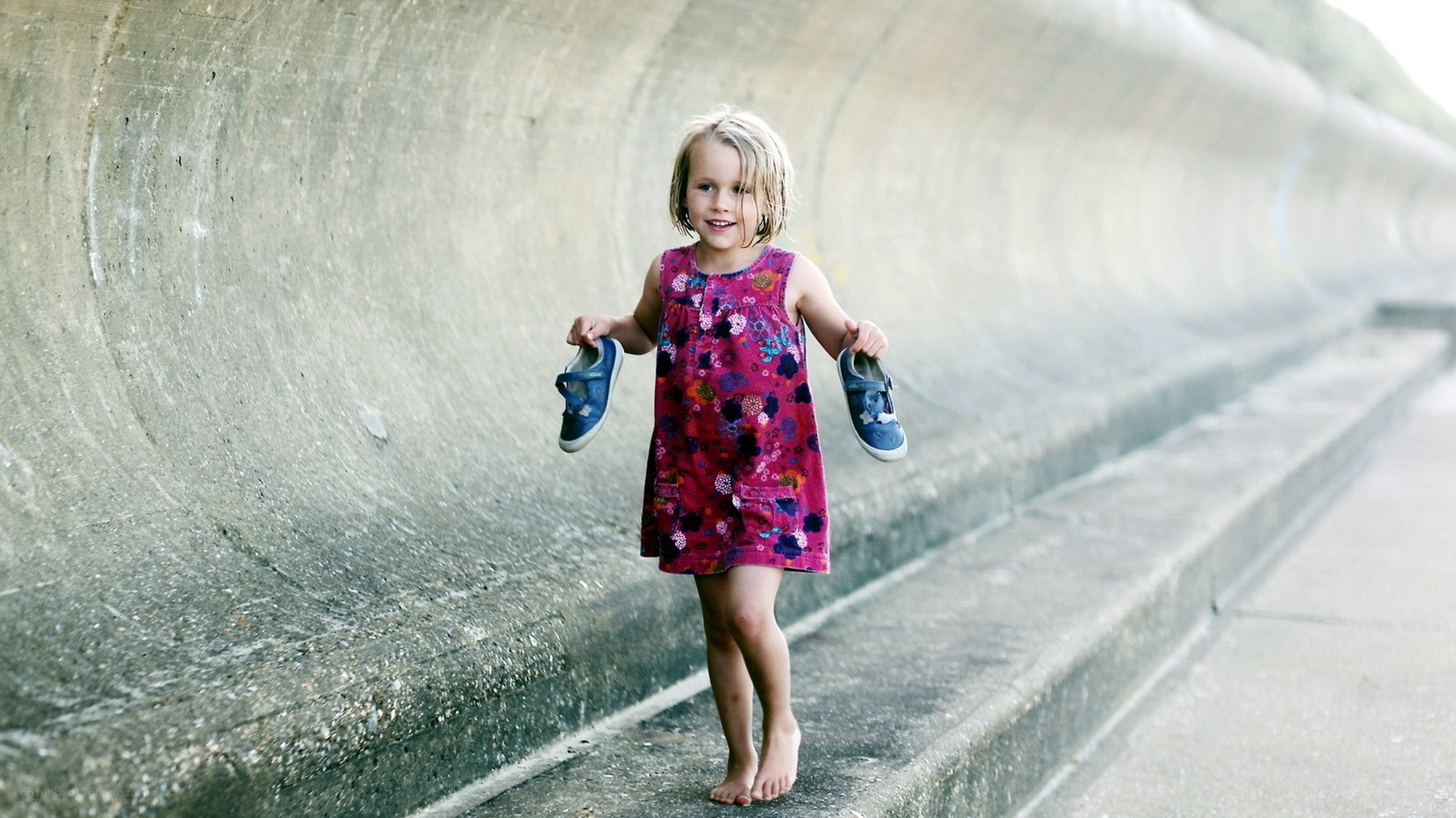 Girl holding shoes barefoot