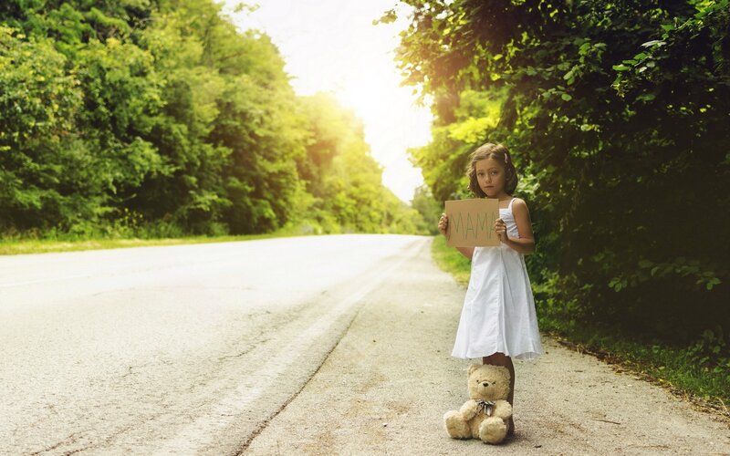 Girl Holding Sign on Road