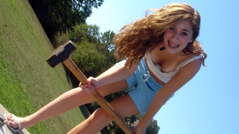 girl holding sledgehammer outdoors