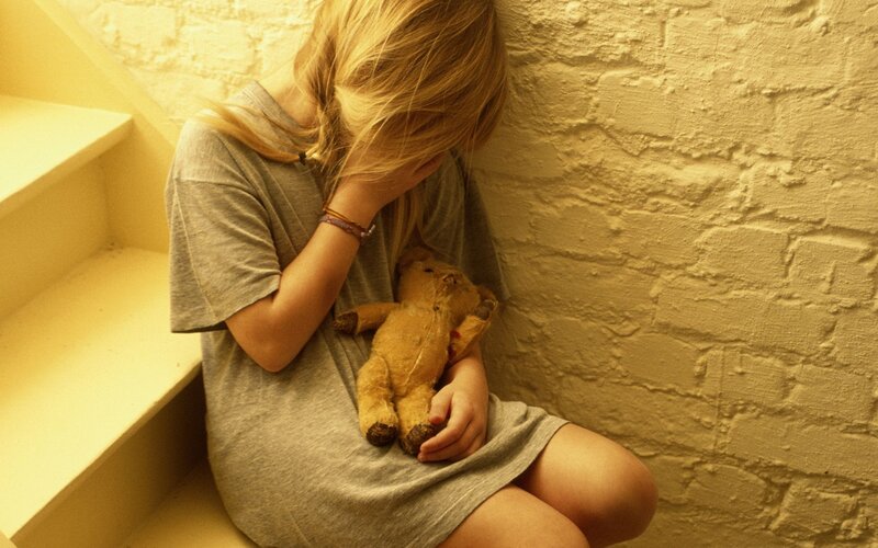 Girl Holding Teddy Bear — Yellow, Somber