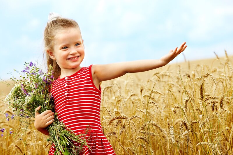 Girl holding wildflowers in a field