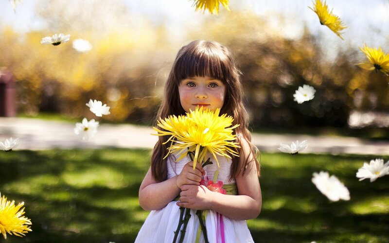 girl holding yellow flowers
