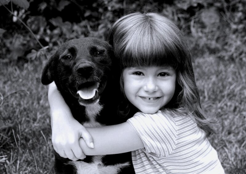 Girl Hugging Black Dog — Happy