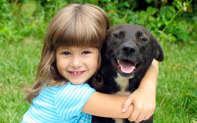 Girl Hugging Black Dog