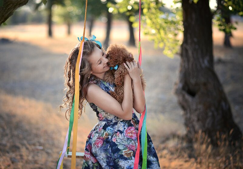 Girl Hugging Dog on Swing