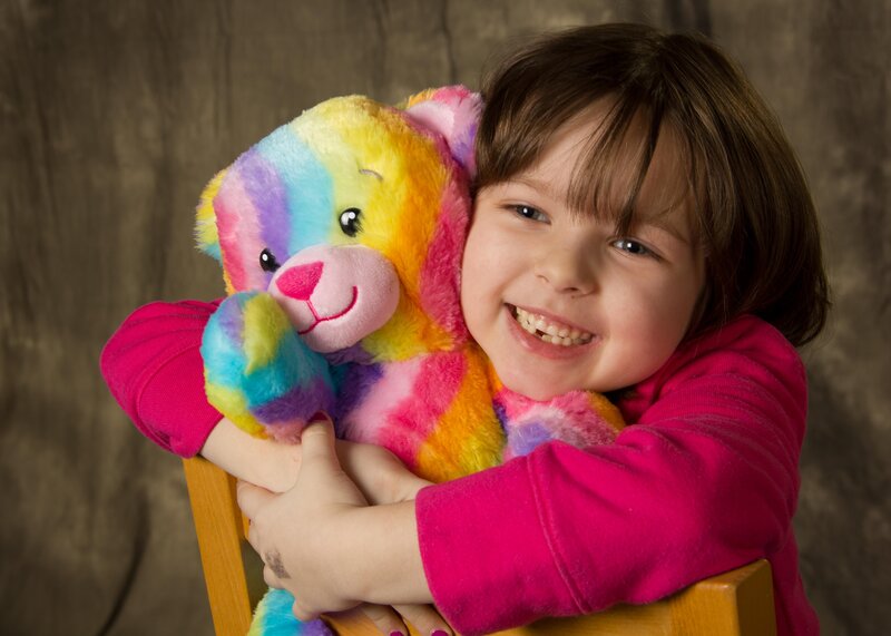 Girl Hugging Rainbow Bear