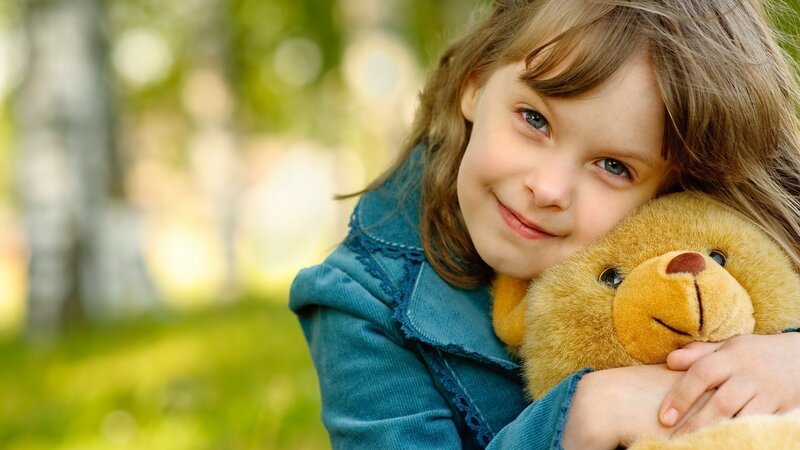 girl hugging teddy bear
