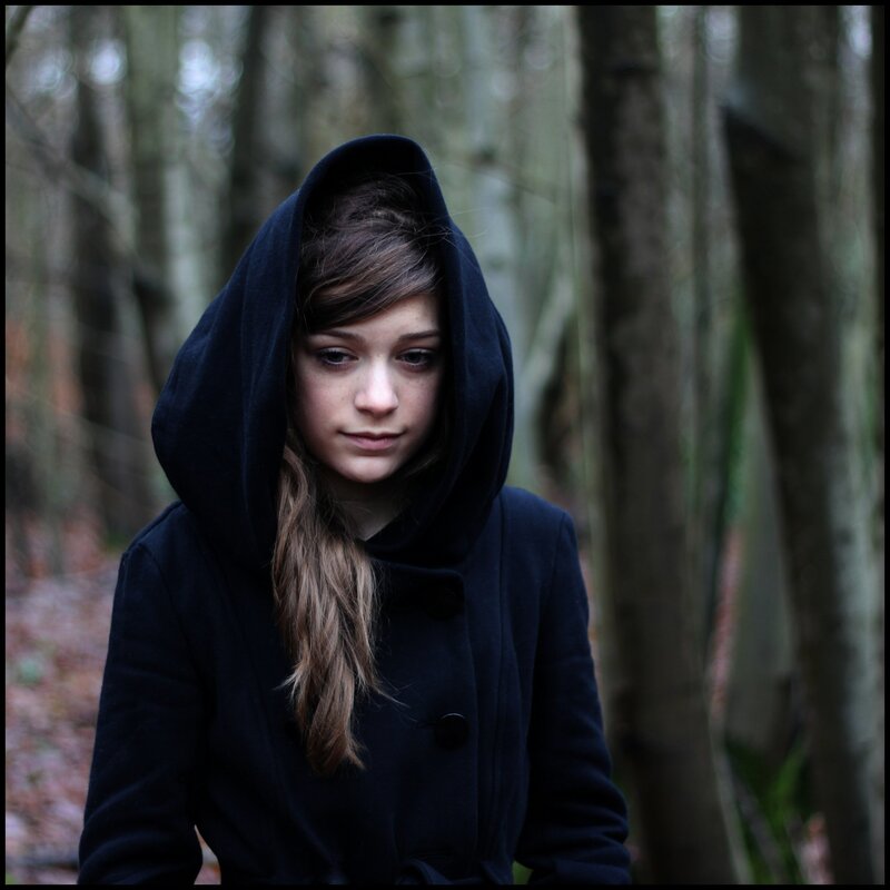 girl in black coat forest