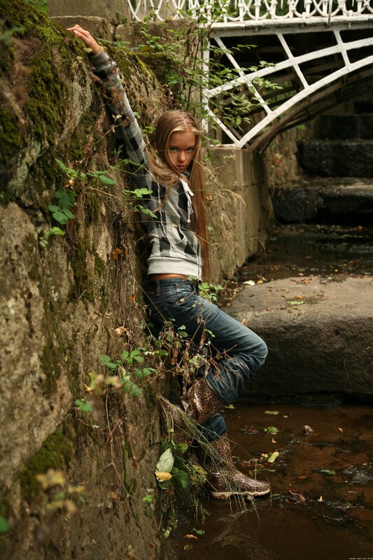 Girl in boots by a stream