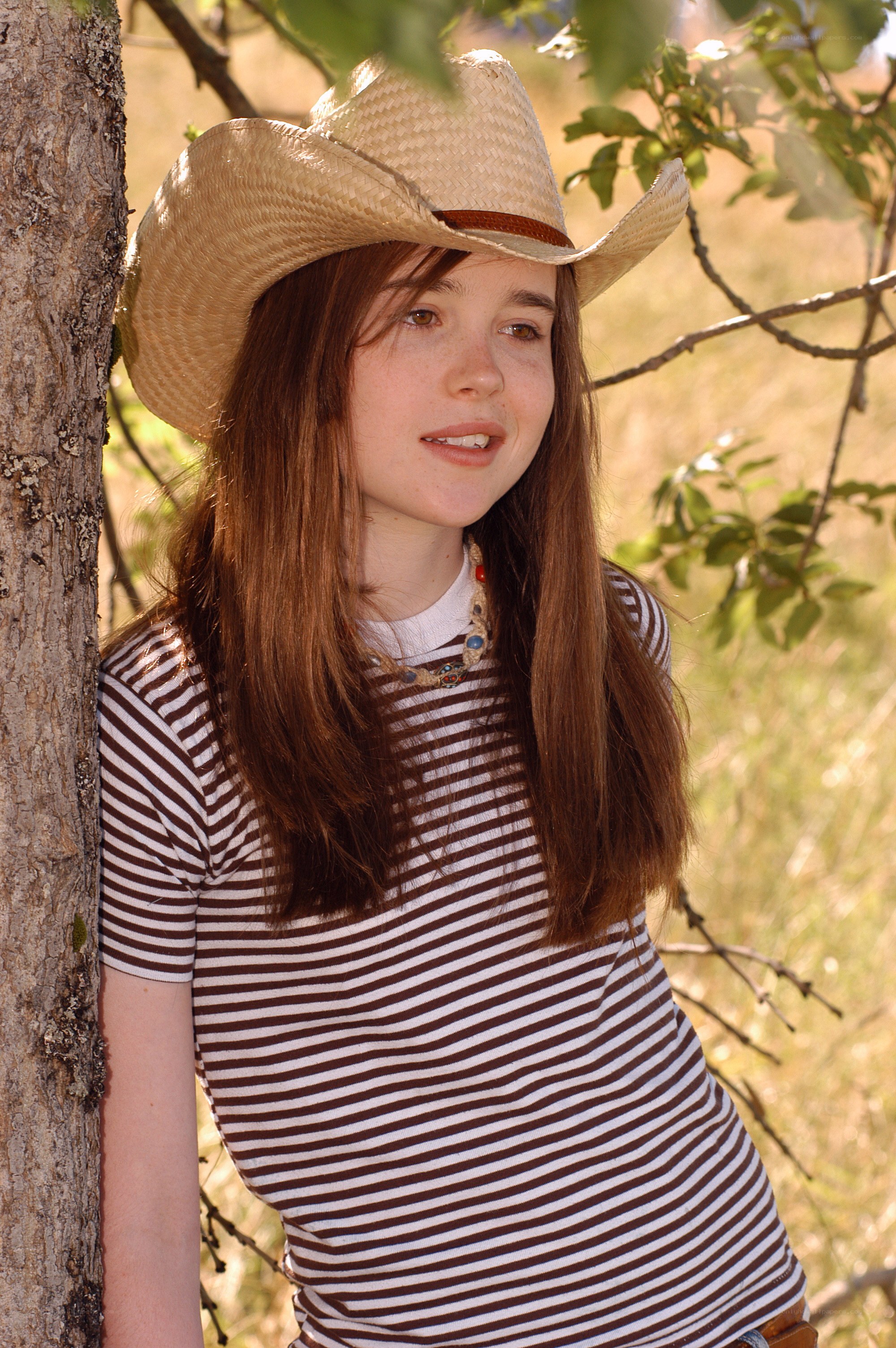 girl in cowboy hat by tree