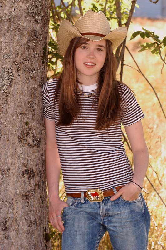 girl in cowboy hat leaning on tree