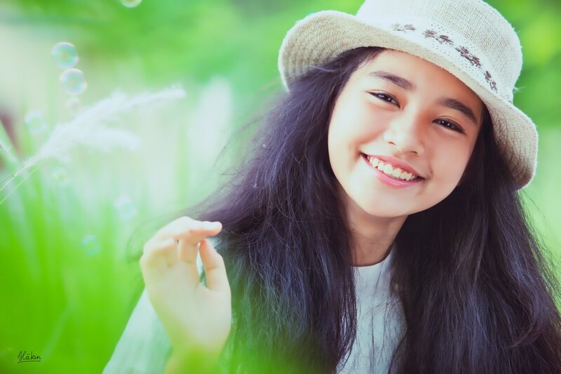 girl in hat smiling outdoors