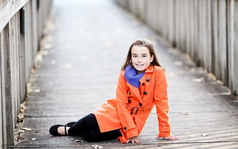 Girl in orange coat on bridge