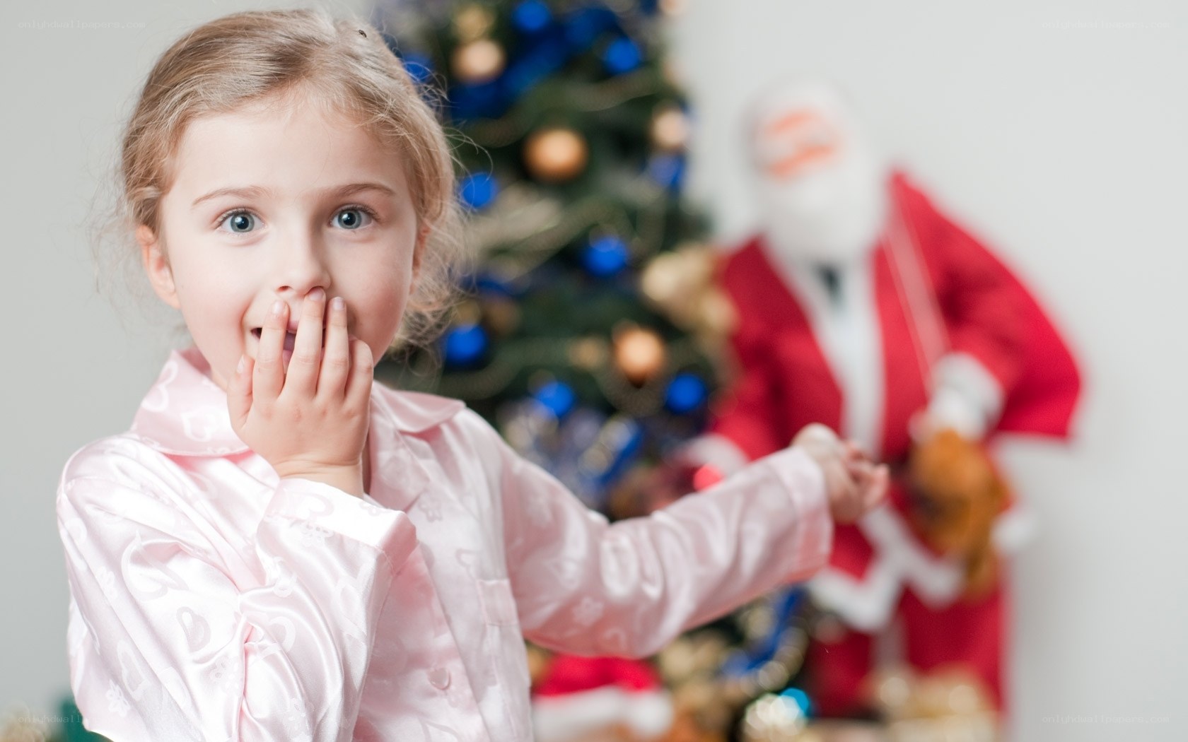 girl in pajamas near Christmas tree