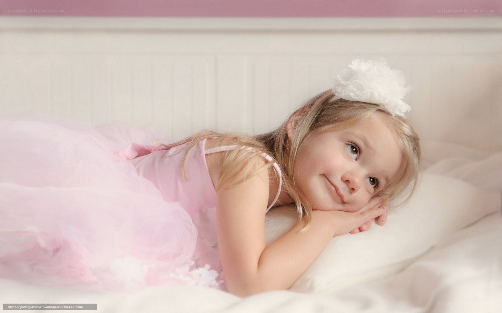 girl in pink dress on bed
