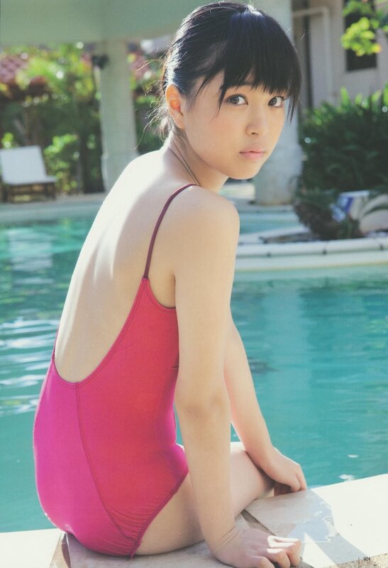 Girl in pink swimsuit by pool