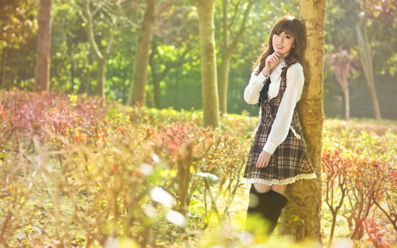 girl in plaid dress by tree