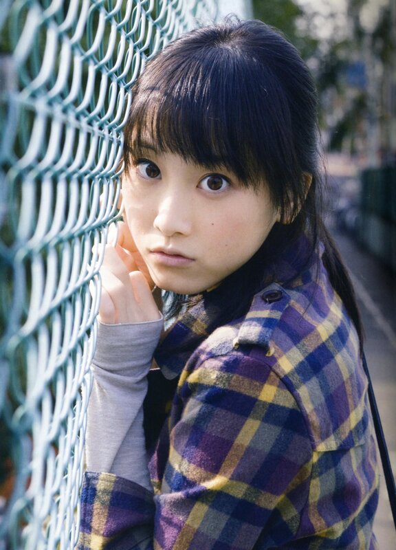 girl in plaid jacket by fence