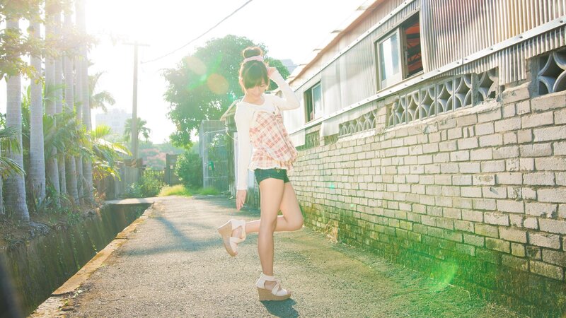 Girl in plaid top on sunny path