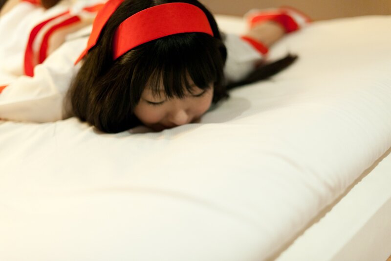 girl in red headband lying on bed