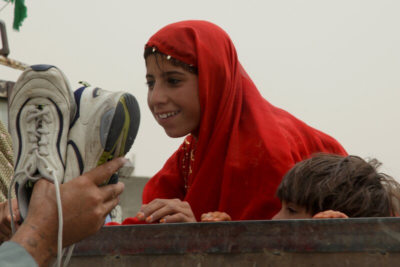 Girl in red hijab smiles at shoes