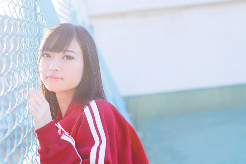 girl in red jacket by fence