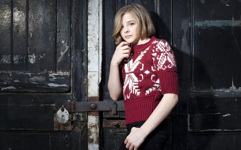 girl in red sweater by door