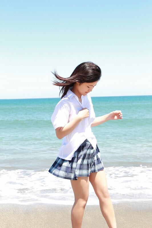 Girl in school uniform at beach