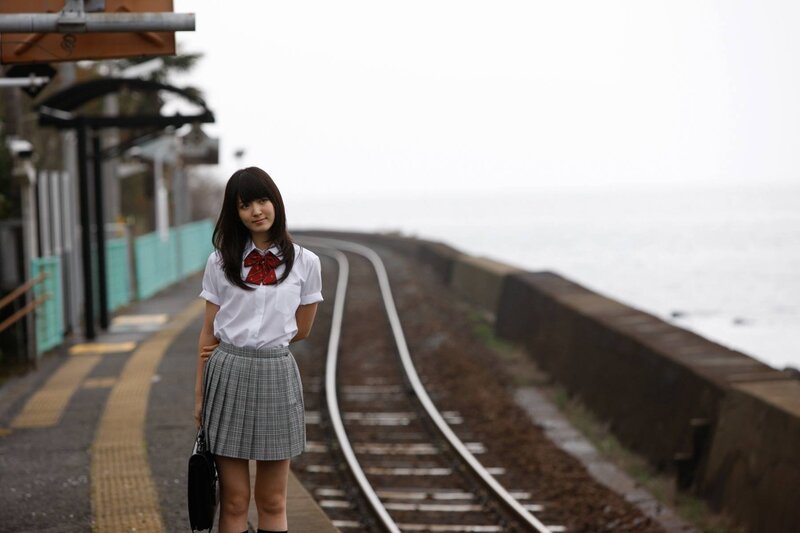 Girl in school uniform at train station